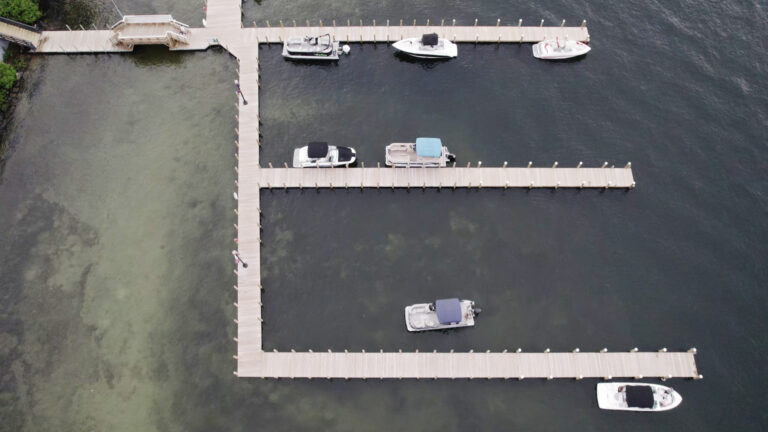 Aerial view of boats docked at a marina on Lake Winnipesaukee, with multiple slips extending into the water.